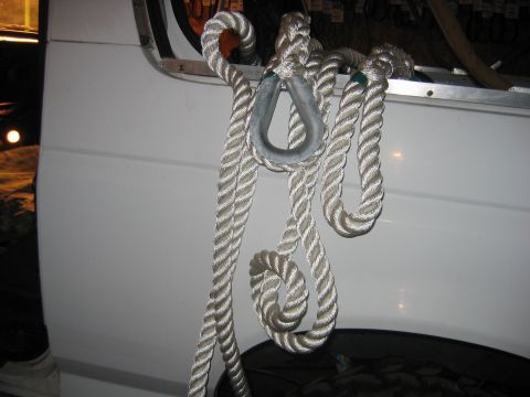 1992 Ford Bronco - A thick rope with a metal loop is secured to the side of a white vehicle.