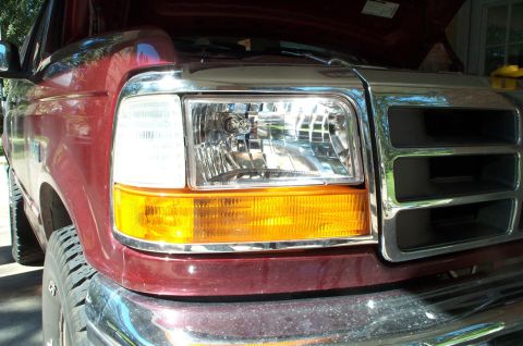 1996 Ford Bronco - Front view of a red 1996 Ford Bronco, showing the grille and headlight assembly.