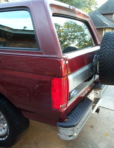 1996 Ford Bronco - Rear view of a maroon 1996 Ford Bronco, showing the spare tire and taillight.