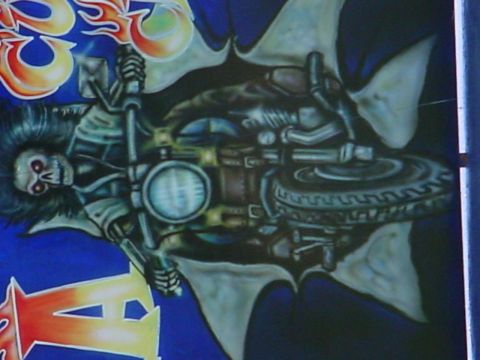 1990 Ford Bronco - Airbrushed artwork depicts a skeleton riding a motorcycle, with flames and wing motifs.