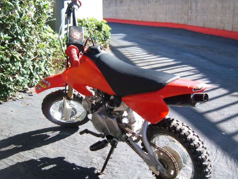 1985 Ford Bronco II - This orange dirt bike is shown from the rear, a black seat and exhaust pipe.