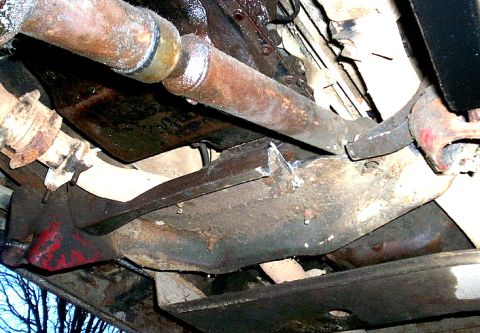 1978 Ford Bronco - This photo shows the rusty undercarriage of a vehicle, focusing on the drivetrain and frame components.