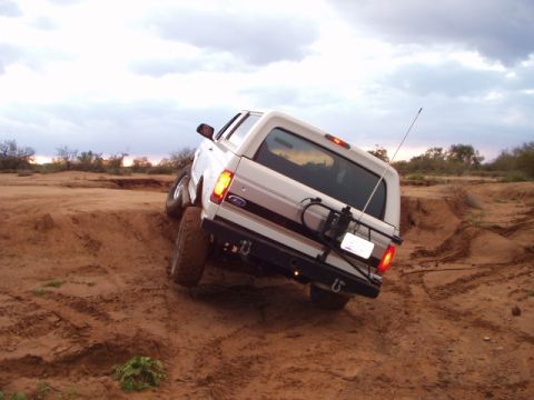 1993 Ford Bronco - White 1993 Ford Bronco navigating rough terrain off-road.