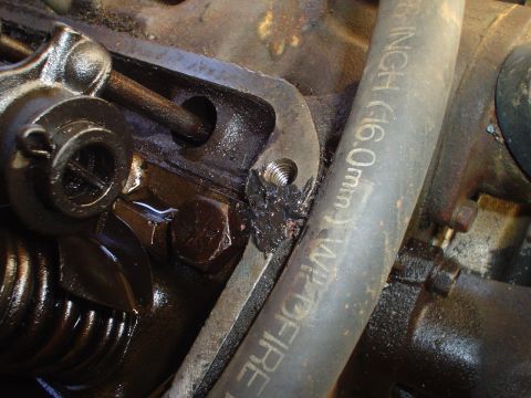 1967 Ford F-250 - A close-up view of internal engine components, including a rocker arm and pushrod, with a hose visible.