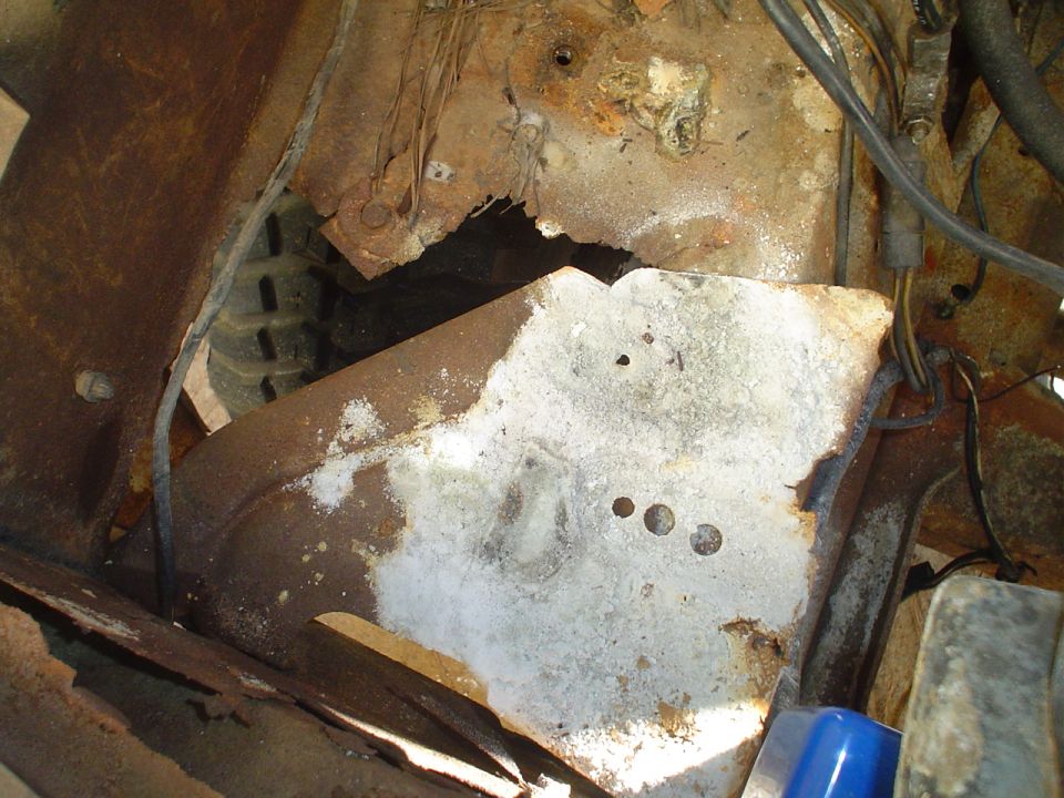 rusted metal and tire visible in vehicle frame area