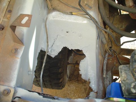 1967 Ford F-250 - Close-up view of a rusted engine bay with a significant hole in the firewall, revealing internal components.