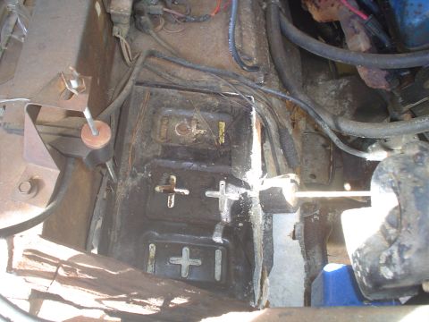 1967 Ford F-250 - The photo shows a close-up view of a vehicle's engine bay, focusing on the battery tray and surrounding mechanical parts.