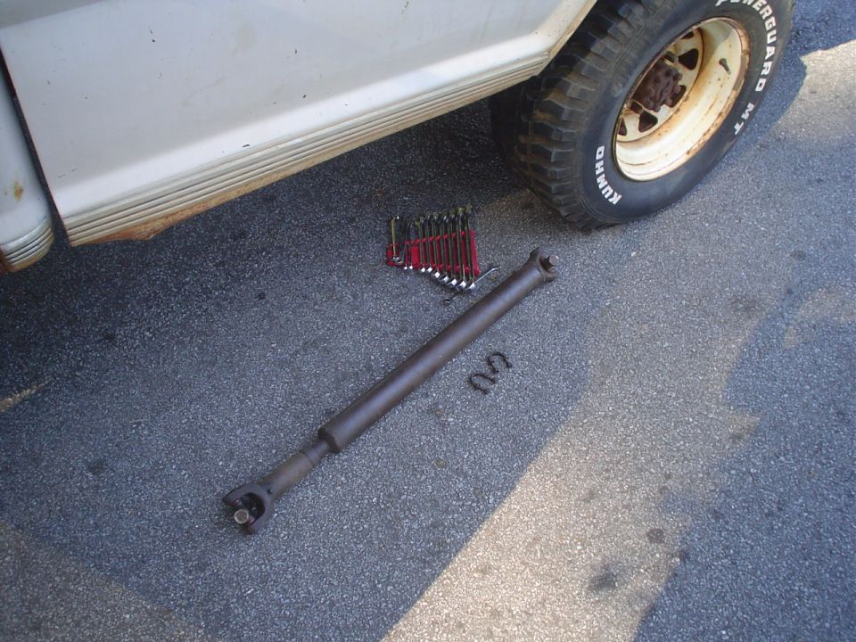 1967 Ford F-250 driveshaft and wrenches on asphalt