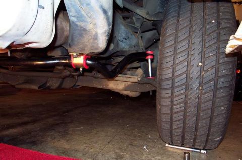 1985 Ford Crown Victoria LTD - Aftermarket sway bar with red and gold bushings installed on the underside of a vehicle.