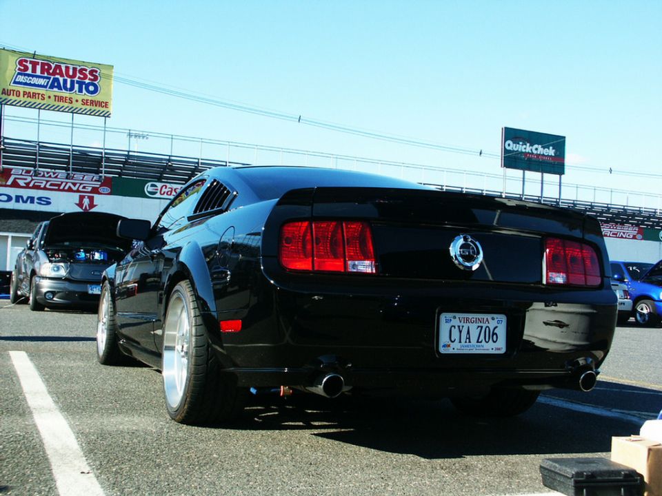 Black Ford Mustang rear view with louvers and custom wheels