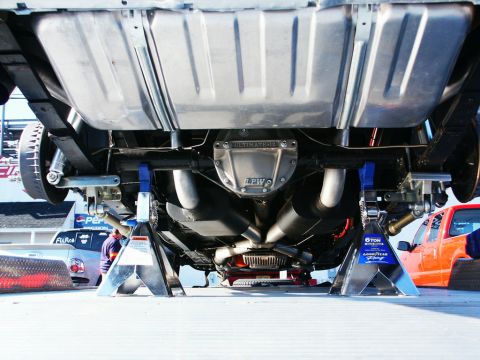2001 Mercury Grand Marquis - Car's undercarriage on jack stands, with other vehicles in the background.
