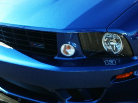 2001 Mercury Grand Marquis - Close-up of a blue car's front end, showing the grille, headlight, and the number 13 emblem.