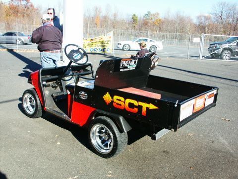 2001 Mercury Grand Marquis - Modified golf cart with utility bed and custom wheels is parked outdoors. Other vehicles are visible in the background.