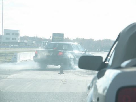 2001 Mercury Grand Marquis - A black 2001 Mercury Grand Marquis performs a burnout on the drag strip, creating a cloud of smoke.