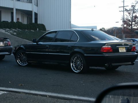 2001 Mercury Grand Marquis - A black sedan with custom wheels is seen from the rear, displaying the license plate RWO-97X.