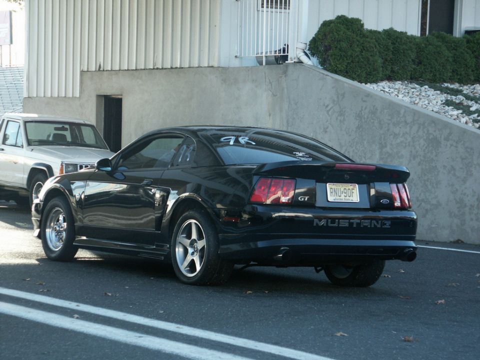 Black Mustang GT parked next to a white Jeep Cherokee