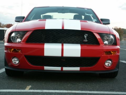 2001 Mercury Grand Marquis - Front view of a red 2007 Ford Mustang Shelby GT500 with iconic white racing stripes.