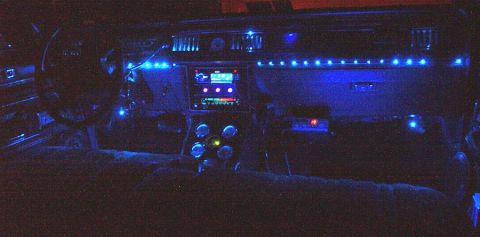1985 Ford Crown Victoria LTD - The dashboard and center console of a car are illuminated by numerous blue LED lights.