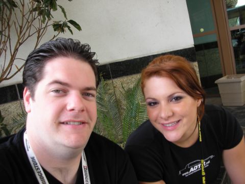 1998 Ford Crown Victoria - man and a smiling red-haired woman pose for a close selfie in front of a stone wall and a potted fern.