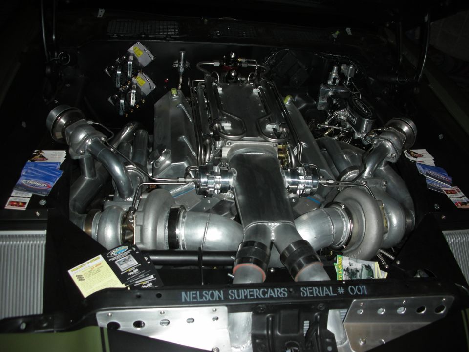 Twin-turbo V-engine in a dark bay labeled Nelson Supercars Serial 001