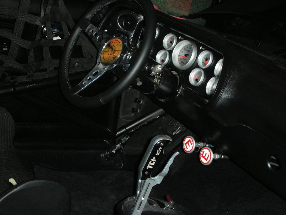 Race car interior with roll cage, Autometer gauges, and a TCI shifter