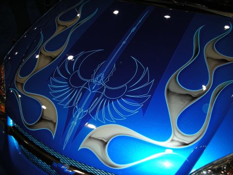 1998 Ford Crown Victoria - close-up of a glossy blue hood painted with an airbrushed phoenix and detailed silver-and-white flame graphics.