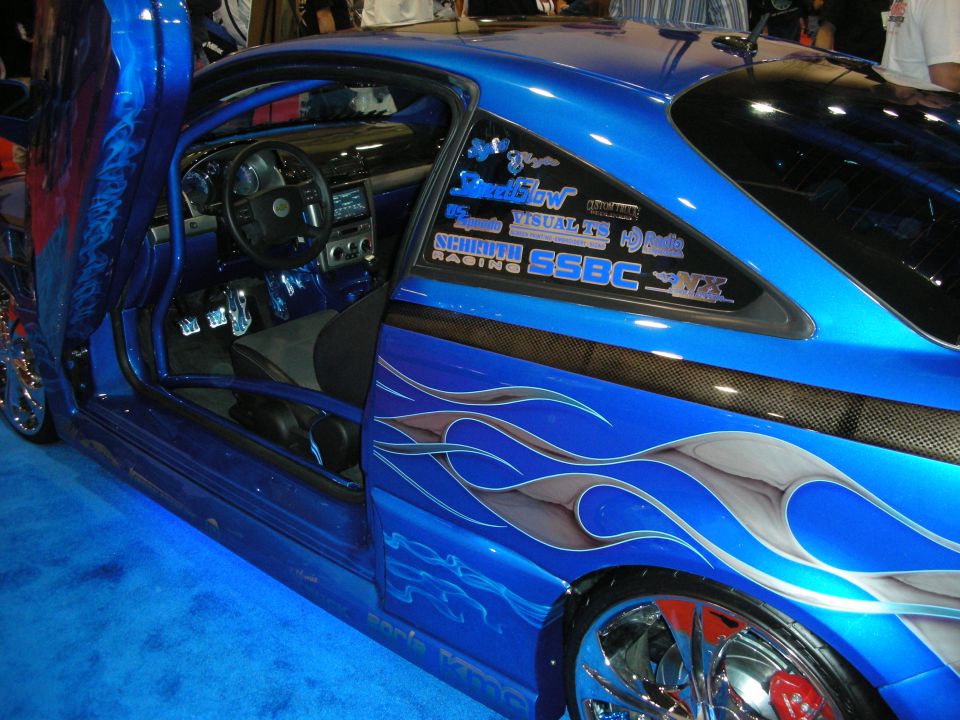 Side of blue custom coupe with open door, flames and sponsor decals