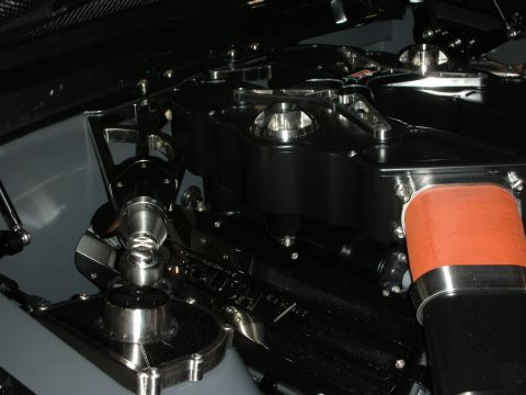 1998 Ford Crown Victoria - close-up of a custom engine bay showing a black billet valve cover, polished components and an orange silicone intake hose.