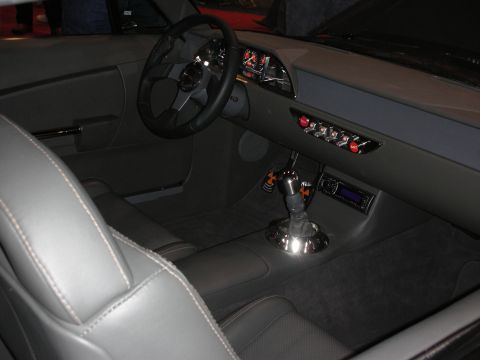 1998 Ford Crown Victoria - custom car interior in gray leather and suede with a steering wheel, chrome floor shifter and a row of toggle switches.