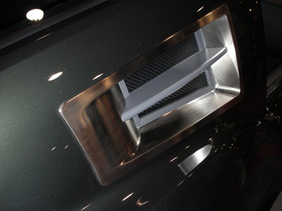 Close-up of machined aluminum and carbon-fiber air scoop on dark body panel