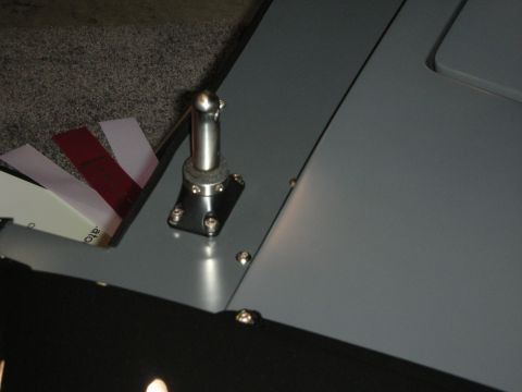 1998 Ford Crown Victoria - gray metal panel fitted with a rivet-mounted ball-stud pivot, with paper sheets tucked behind it.