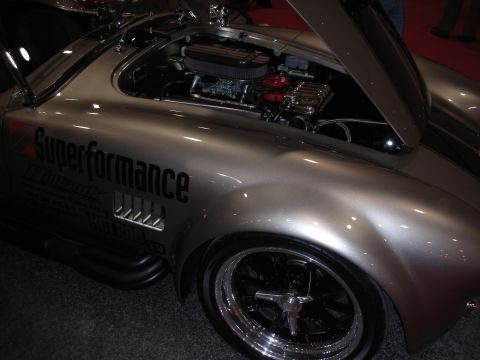 1998 Ford Crown Victoria - Silver Superformance roadster shown with hood up exposing the engine, sitting on a chrome five-spoke wheel.