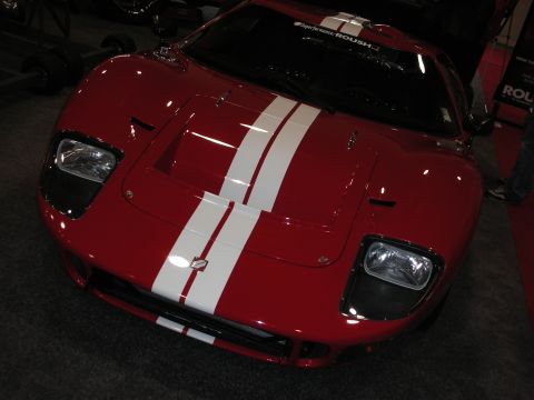 1998 Ford Crown Victoria - Front view of a red mid-engine sports car with twin white racing stripes and quad round headlights.