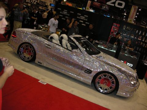 1998 Ford Crown Victoria - Crystal-covered Mercedes convertible with white fur seat covers displayed on red carpet at the DAD booth.