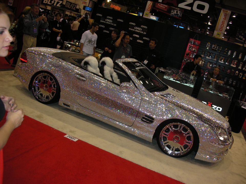 Crystal-covered Mercedes convertible with fur seats on a red carpet at the DAD booth
