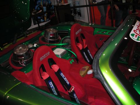 1998 Ford Crown Victoria - Interior of a green custom car fitted with red Sparco bucket seats, racing harnesses and trunk subwoofers.