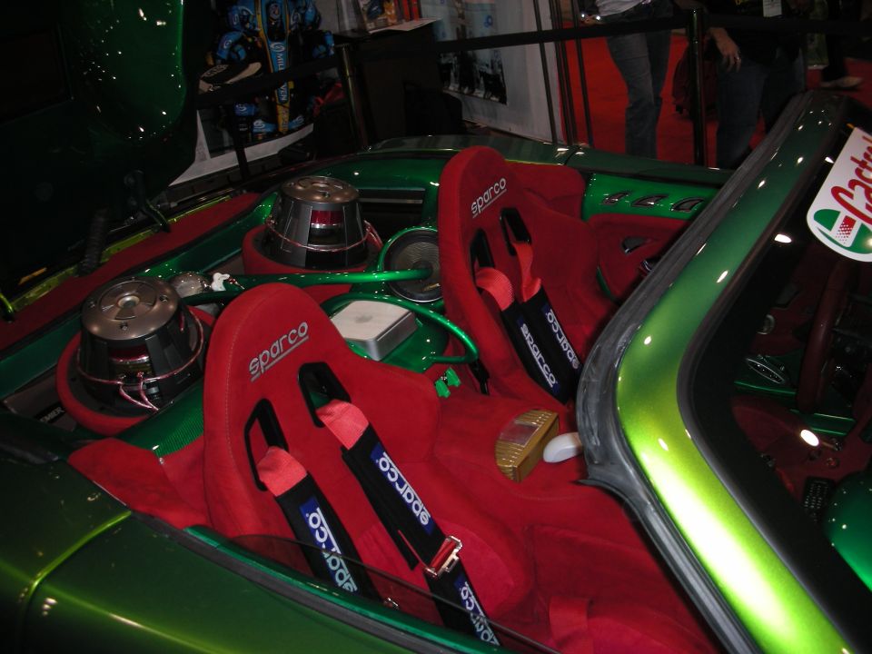 Green show car interior with red Sparco bucket seats, harnesses and audio subwoofers