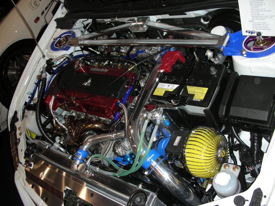 Detailed turbocharged engine bay with red valve cover and blue plumbing