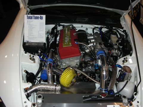 1998 Ford Crown Victoria - polished turbocharged engine with a red cover, chrome piping and yellow filter fills a white engine bay beside a Total Tune-Up sheet.