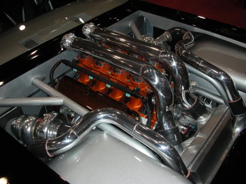 1998 Ford Crown Victoria - heavily polished twin-turbo V8 with orange intake runners and chrome plumbing sits in a silver engine bay.