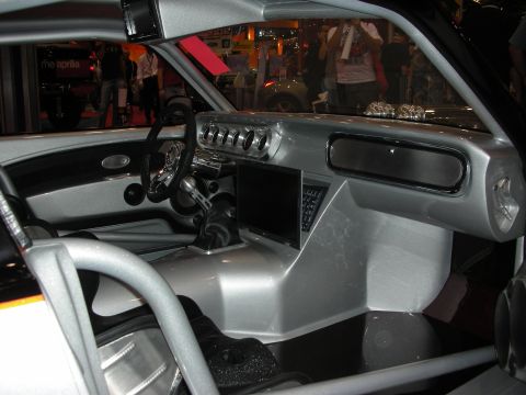 1998 Ford Crown Victoria - bespoke silver car interior shows a tubular roll cage, sculpted dash and a small LCD screen on the center console.