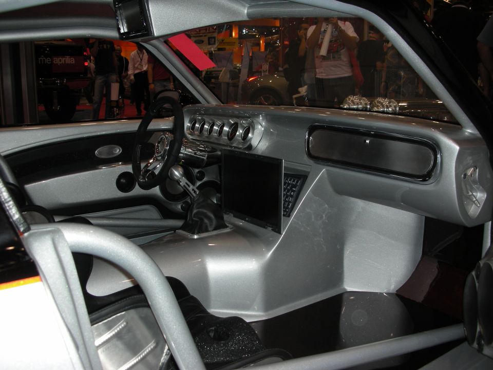 Custom silver car interior with roll cage and center LCD screen