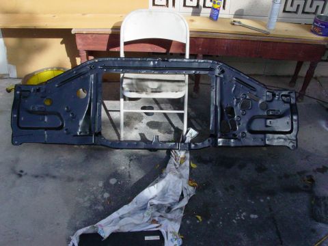 1979 Ford Bronco - A dark blue metal radiator support assembly is shown from the front, resting on a concrete surface.