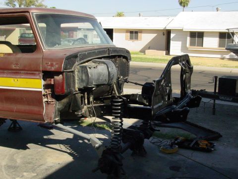 1979 Ford Bronco - The front clip of a 1979 Ford Bronco has been removed, exposing the chassis and suspension system during a repair or restoration process.