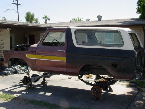 1979 Ford Bronco - This Ford Bronco appears to be undergoing significant repairs or modifications, with its body elevated on stands and suspension components…