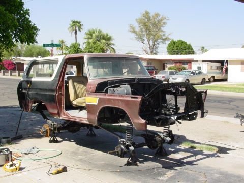 1979 Ford Bronco - A disassembled 1978 Ford Bronco sits on jack stands in a driveway, awaiting restoration.