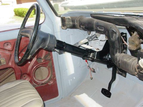 1979 Ford Bronco - The interior of a vehicle, likely undergoing restoration, reveals the steering column, pedals, and dashboard structure.