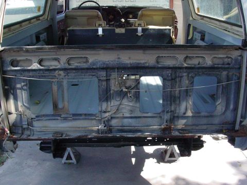 1979 Ford Bronco - The rear of a Ford Bronco is shown with the tailgate removed, revealing its internal structure and seating area.