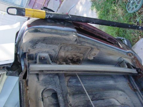1979 Ford Bronco - The image shows a close-up view of a vehicle's fender and hood hinge area, revealing significant rust and wear.