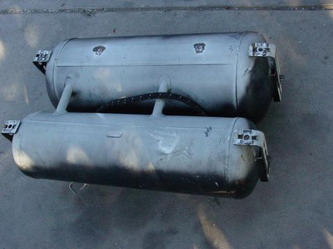 1979 Ford Bronco - Two silver propane tanks are shown, each with metal mounting brackets attached to the ends.